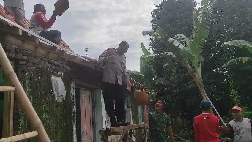 Bhabinkamtibmas Desa Ronowijayan gotong royong bersama masyarakat perbaiki rumah terdampak hujan angin