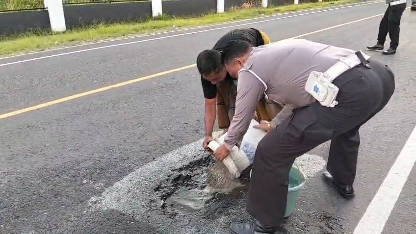 Kepedulian Personel Pos Lantas 12.0 Maospati Bersama Warga Perbaiki Jalan Berlubang Demi Cegah Kecelakaan